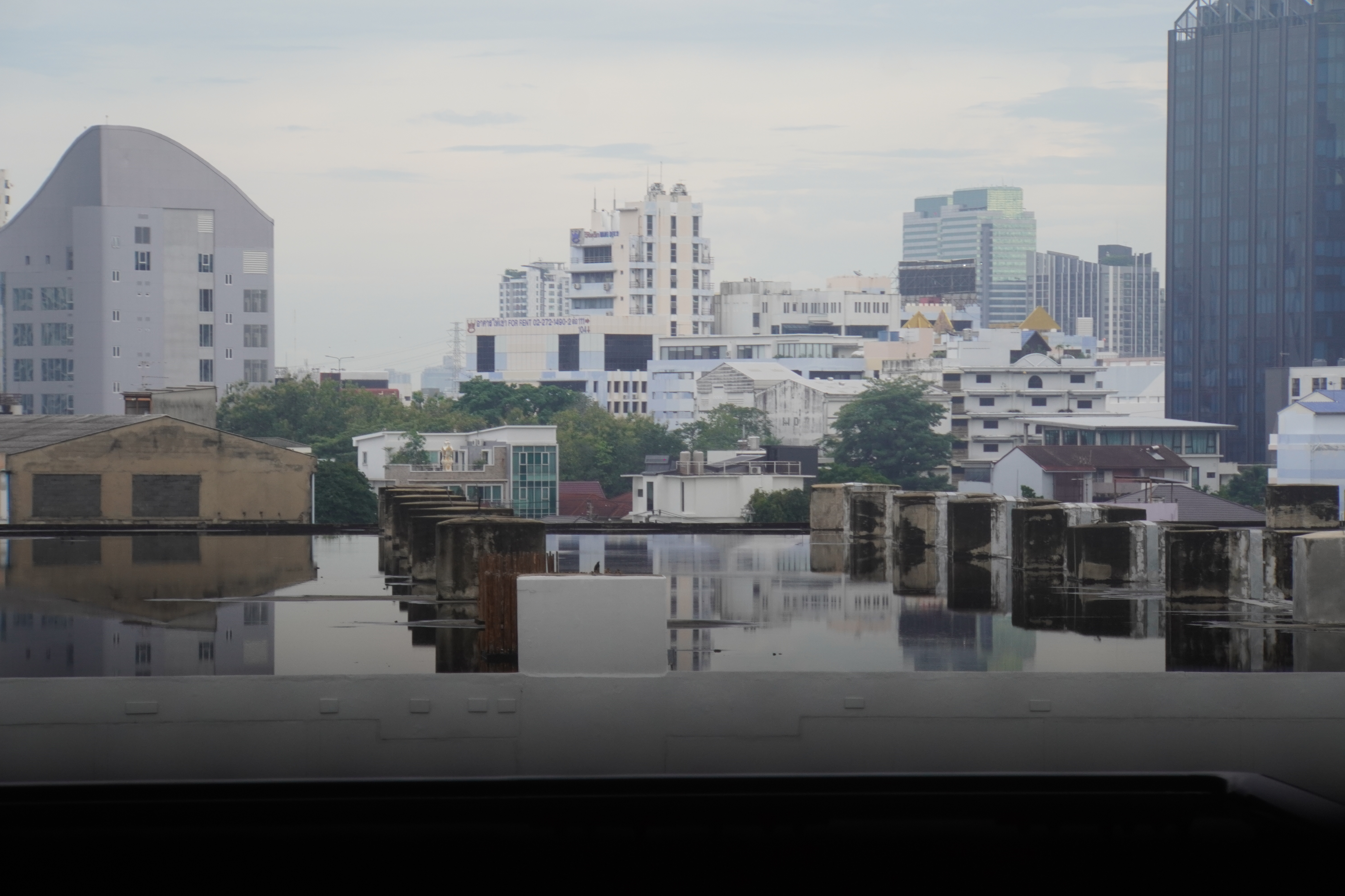 gespiegelte Hochhäuser im Regenwasser